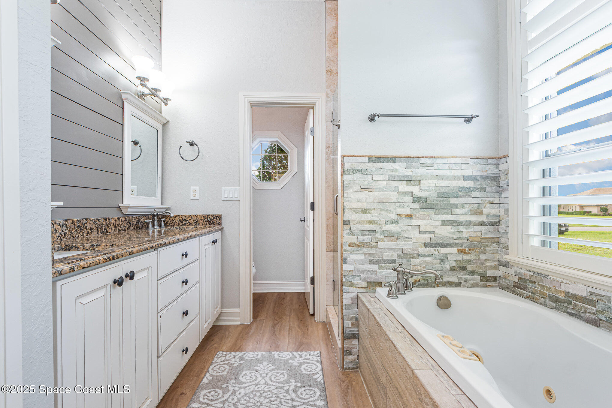 3260 Quantum Place Mims, FL 32754 - Photo 20 of 43 a bathroom with a granite countertop tub a sink and a large mirror