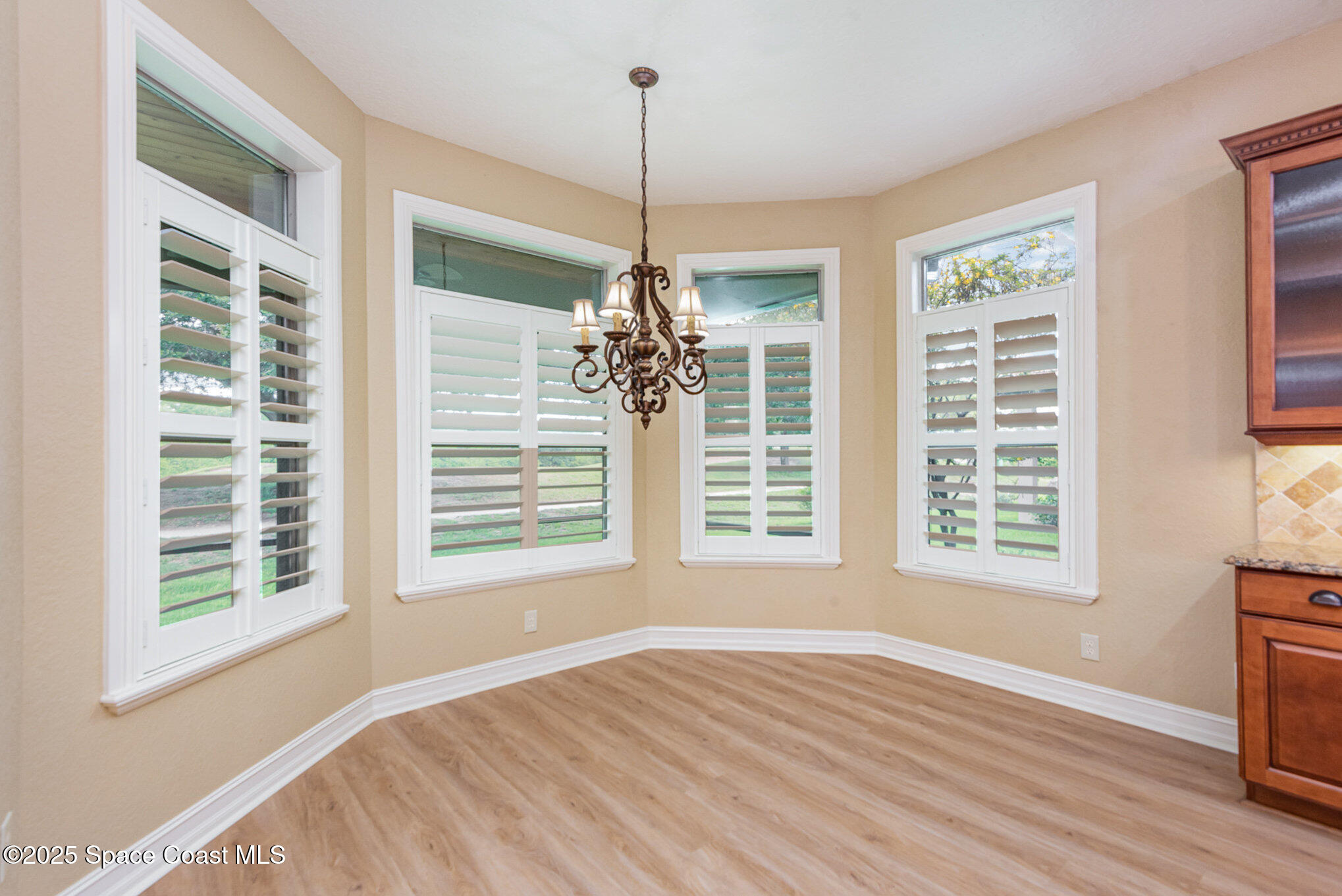 3260 Quantum Place Mims, FL 32754 - Photo 10 of 43 a view of an empty room with a window and wooden floor