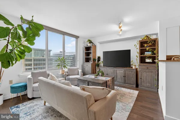 a living room with furniture a flat screen tv and a large window