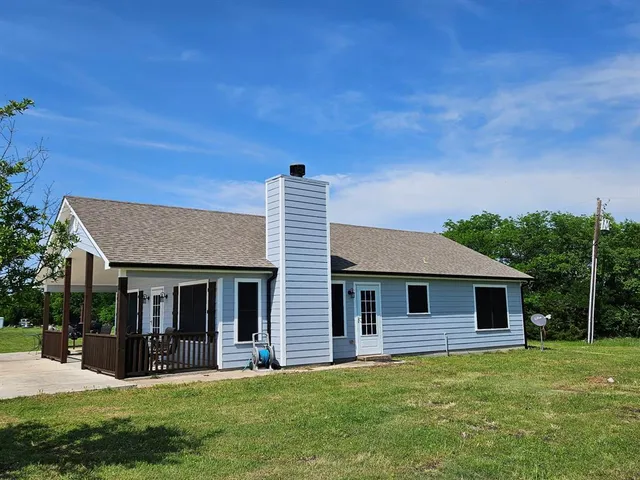 a front view of a house with a yard and trees