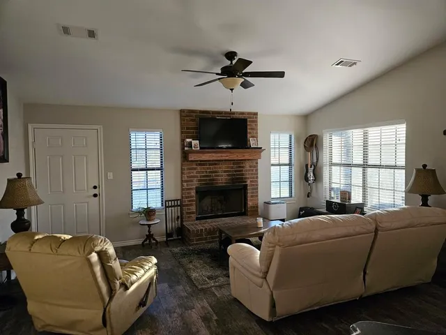 a living room with furniture a flat screen tv and a fireplace