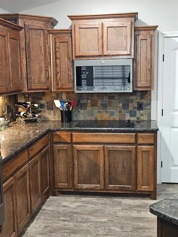 a kitchen with stainless steel appliances granite countertop a sink and cabinets