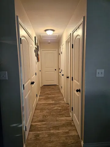 a view of a hallway with wooden floor and staircase