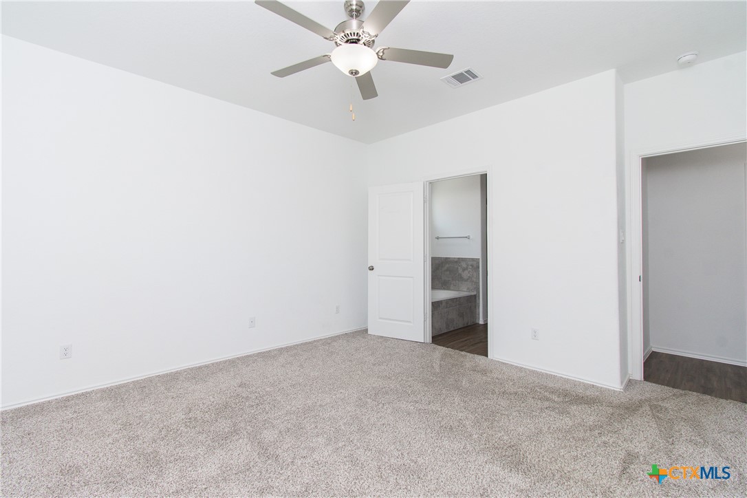 9101 Daisy Cutter Crossing Georgetown, TX 78626 - Photo 11 of 28 an empty room with closet and a ceiling fan