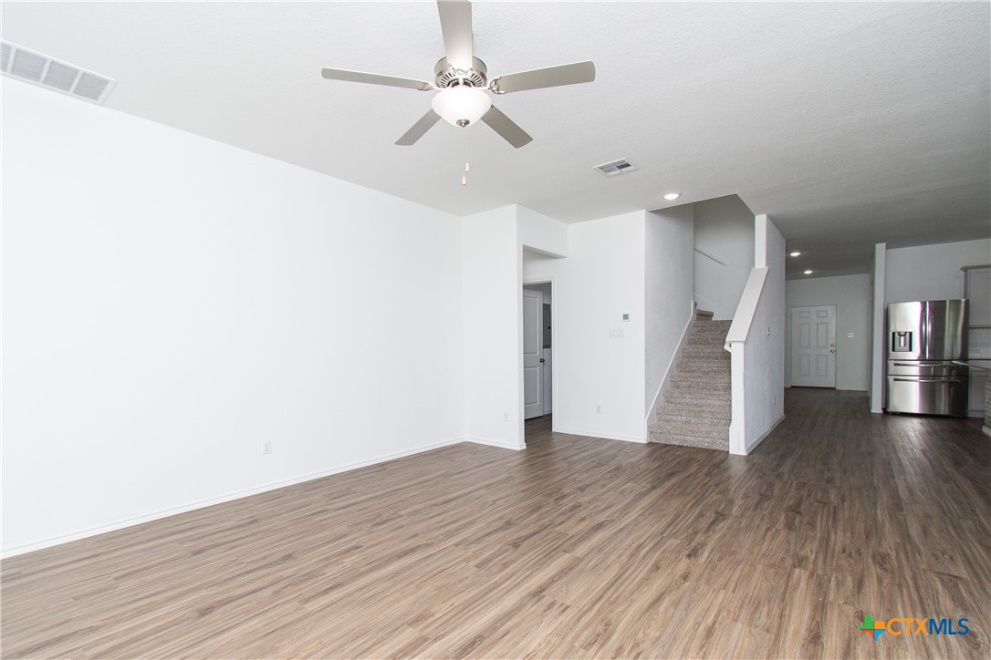 9101 Daisy Cutter Crossing Georgetown, TX 78626 - Photo 2 of 28 a view of a livingroom with wooden floor and a ceiling fan