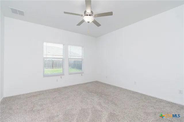 an empty room with a window and a ceiling fan