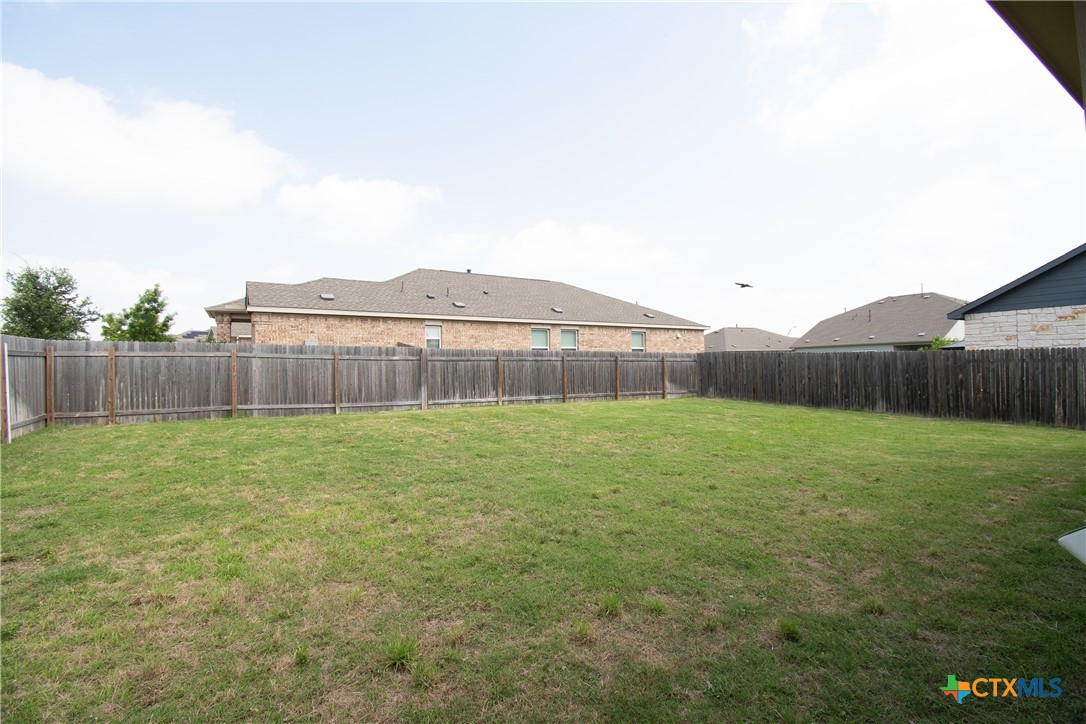 9101 Daisy Cutter Crossing Georgetown, TX 78626 - Photo 28 of 28 a view of a backyard with grass and wooden fence