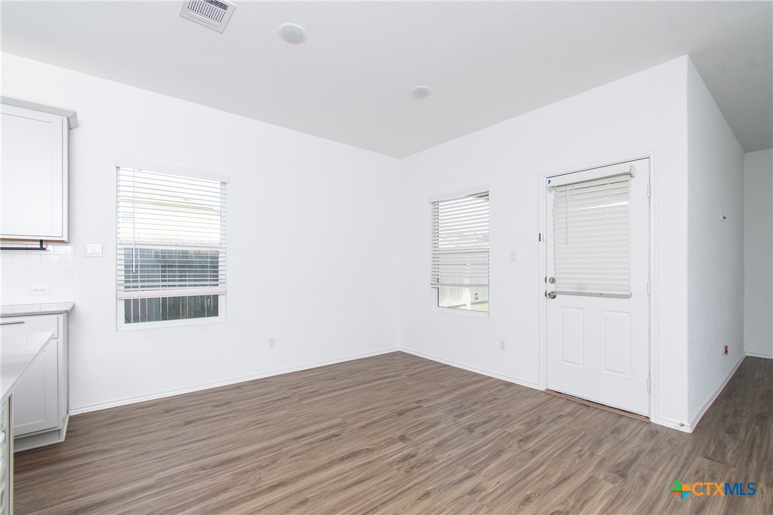 9101 Daisy Cutter Crossing Georgetown, TX 78626 - Photo 5 of 28 an empty room with wooden floor and windows