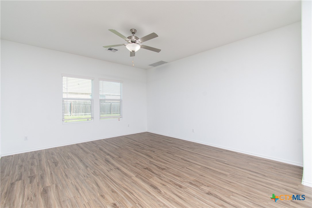 9101 Daisy Cutter Crossing Georgetown, TX 78626 - Photo 7 of 28 a view of an empty room with wooden floor and a window