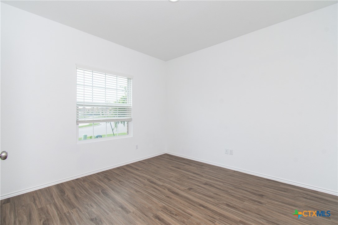 9101 Daisy Cutter Crossing Georgetown, TX 78626 - Photo 9 of 28 an empty room with wooden floor and windows