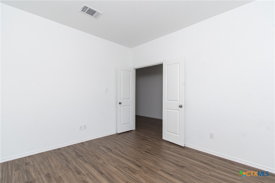 9101 Daisy Cutter Crossing Georgetown, TX 78626 - Photo 10 of 28 a view of an empty room with wooden floor