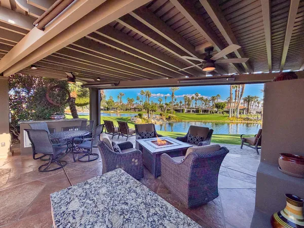 a view of a patio with a table chairs and a backyard