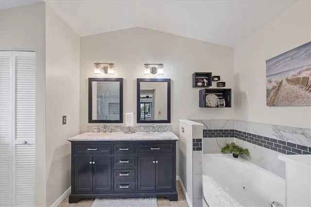 a spacious bathroom with a granite countertop tub sink and mirror