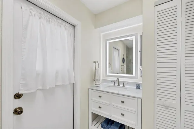 a bathroom with a granite countertop sink a mirror and shower