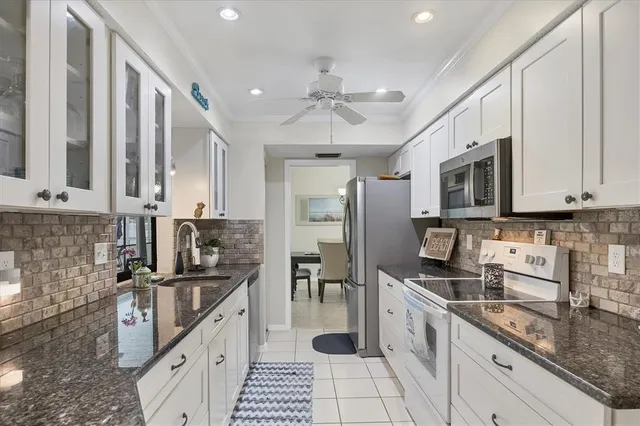 a kitchen with granite countertop a sink stainless steel appliances and cabinets