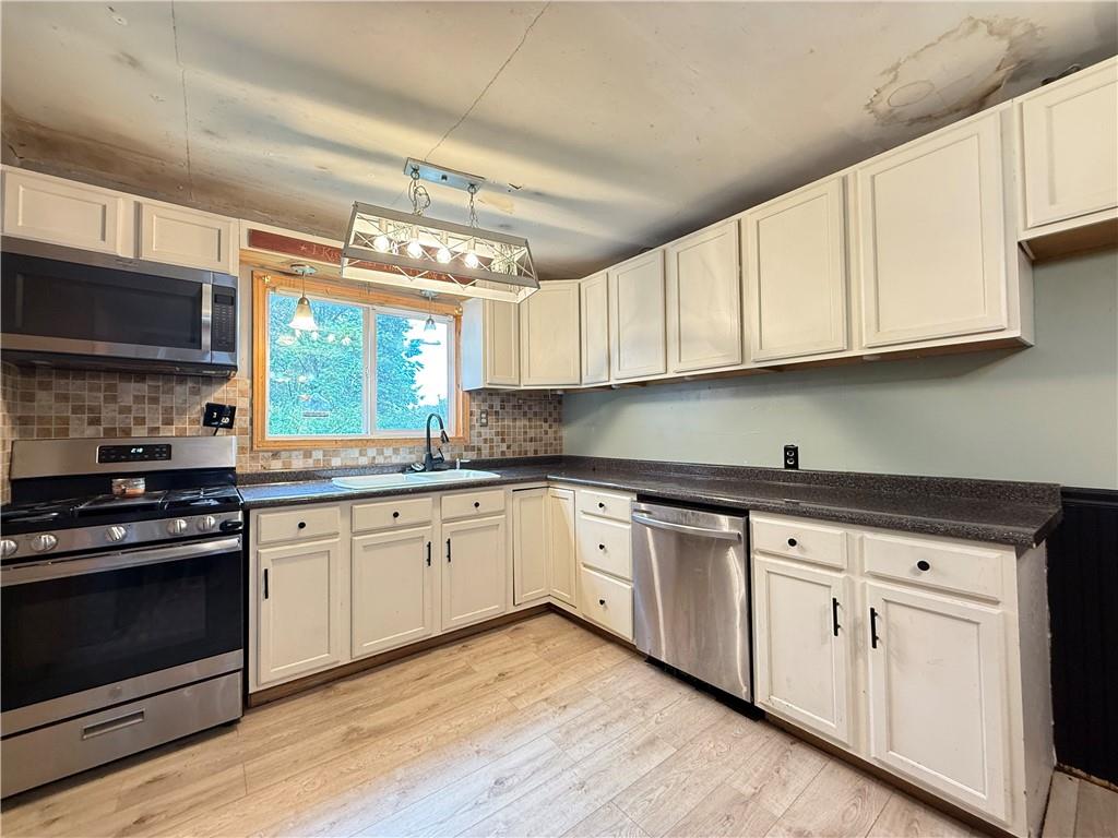 63 Fredonia Road Greenville, PA 16125 - Photo 12 of 32 a kitchen with granite countertop white cabinets stainless steel appliances and a sink