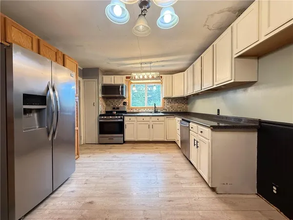 a kitchen with granite countertop a refrigerator and a sink