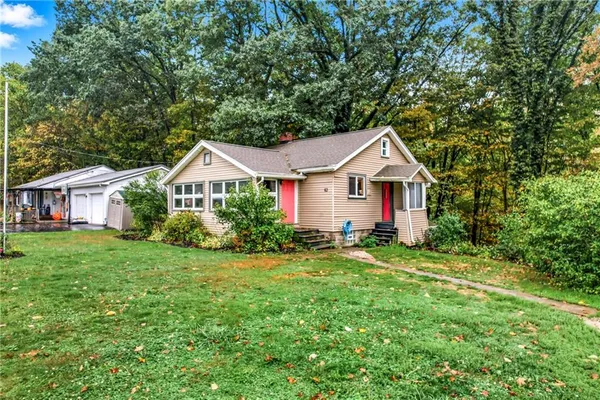 a front view of a house with a yard and trees