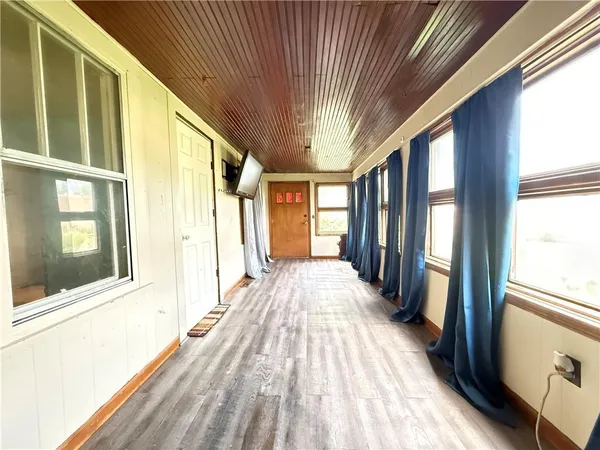 a view of a hallway with wooden floor and stairs