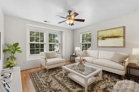 a living room with furniture a chandelier and a rug
