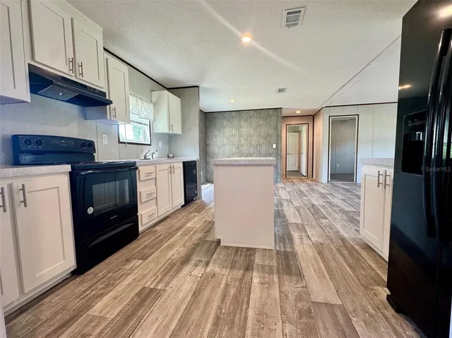 a kitchen with a sink and wooden floor
