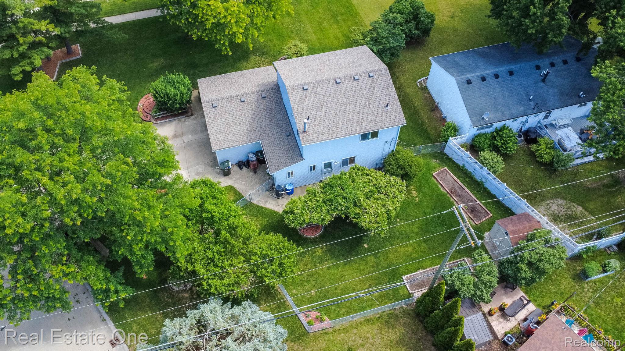 13912 Clinton River Road Sterling Heights, MI 48313 - Photo 39 of 43 Two-story residence featuring light blue siding, a gray shingle roof, and a concrete patio