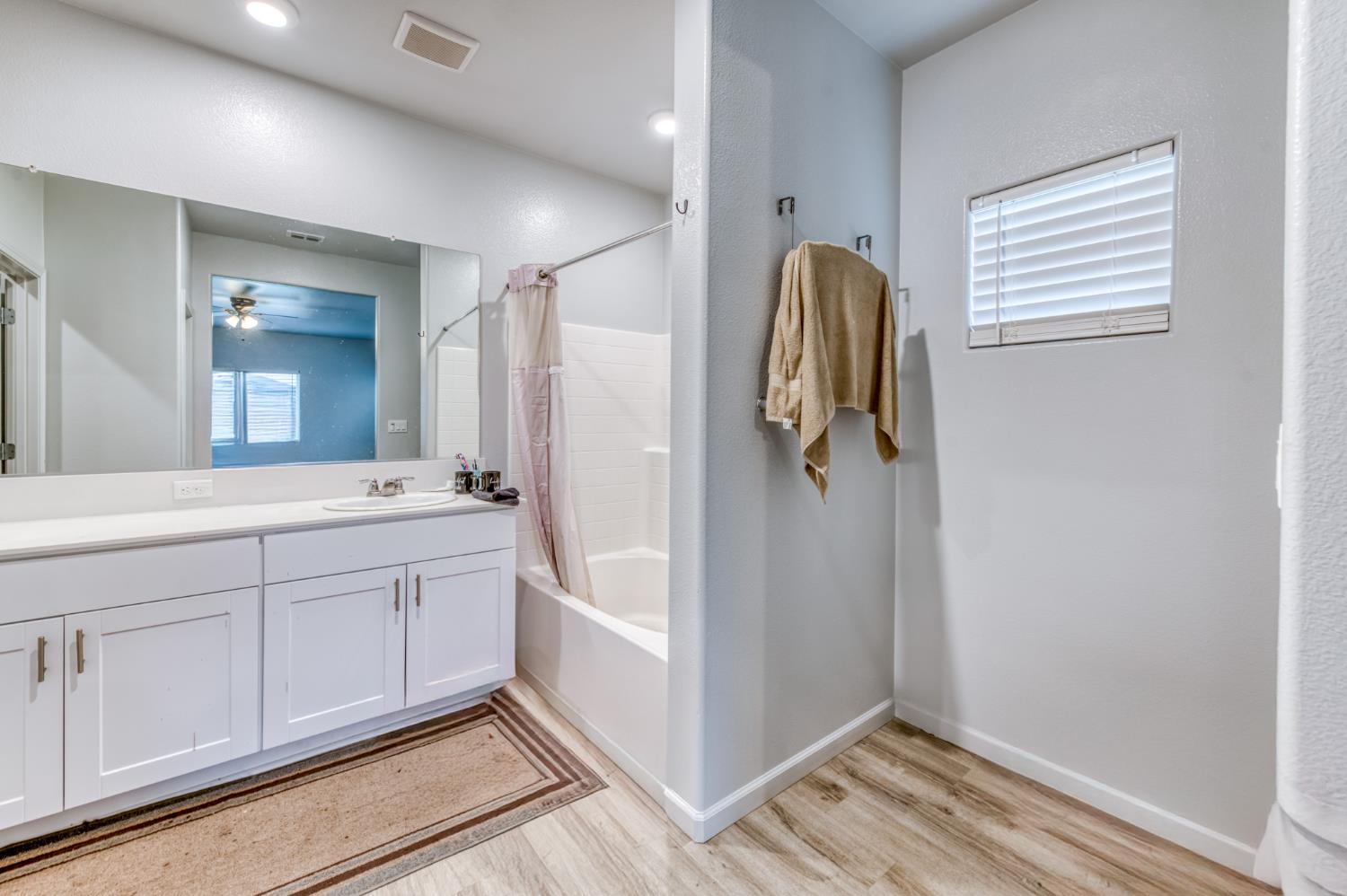 1391 Shoreside Drive Madera, CA 93637 - Photo 11 of 30 a bathroom with a sink a mirror and shower