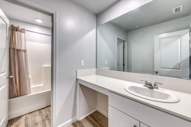 an empty room with windows and a chandelier fan