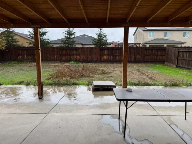 a backyard of a house with barbeque oven table and chairs