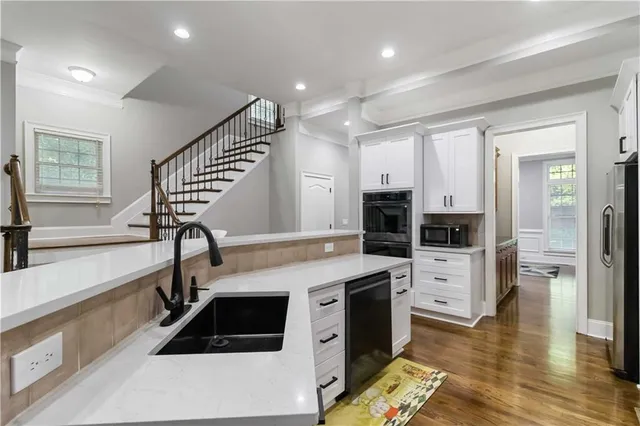 a kitchen that has a lot of cabinets and wooden floor