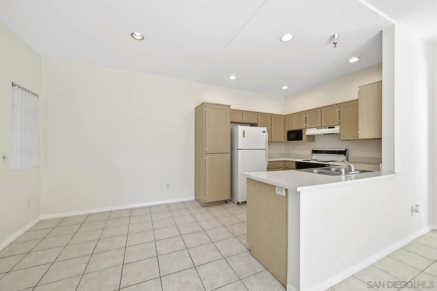17161 Alva Road, Unit 2416 San Diego, CA 92127 - Photo 9 of 26 a kitchen with a refrigerator a stove top oven and a counter space