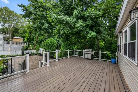 a view of a deck with wooden floor and fence next to a yard