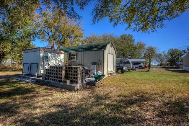 a view of a house with backyard and trees