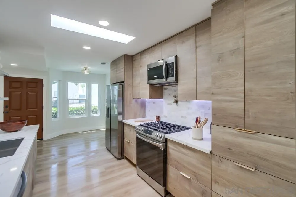 175 Bronze Way Vista, CA 92083 - Photo 3 of 33 a kitchen with stainless steel appliances kitchen island granite countertop a stove a sink and a refrigerator