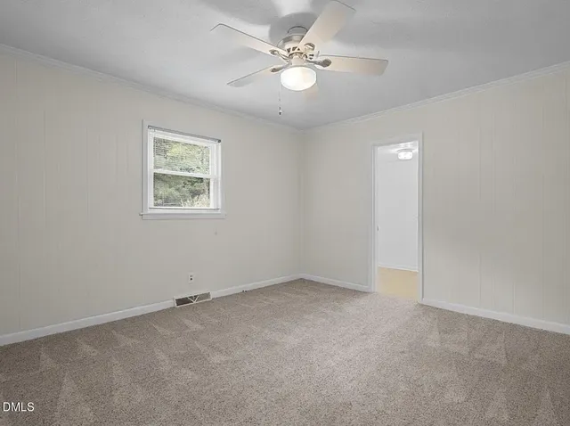 a bathroom with a granite countertop toilet a sink a mirror and a window