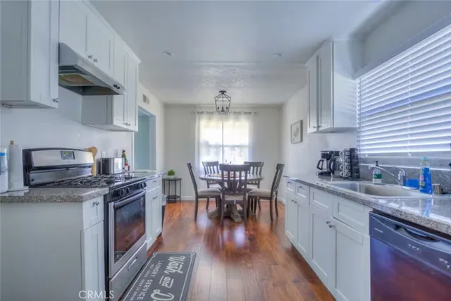 a kitchen with granite countertop furniture wooden floor and stainless steel appliances
