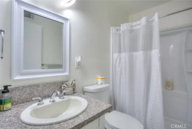 a bathroom with a sink toilet and a mirror