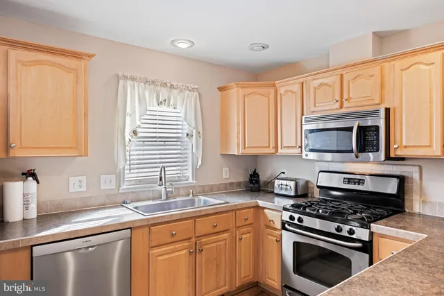 a kitchen with stainless steel appliances granite countertop a sink stove and microwave