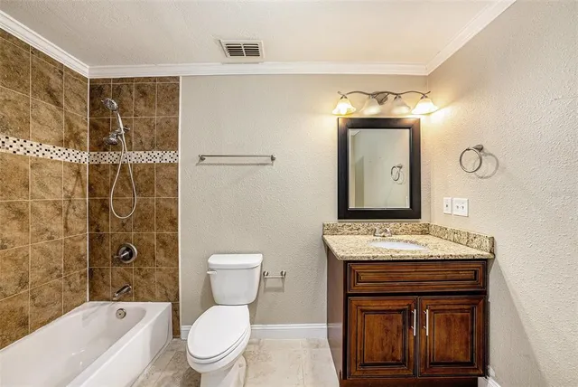 a bathroom with a granite countertop toilet sink and mirror