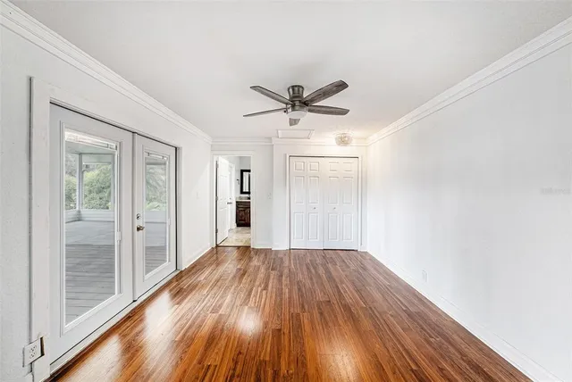 a view of a room with wooden floor and a ceiling fan