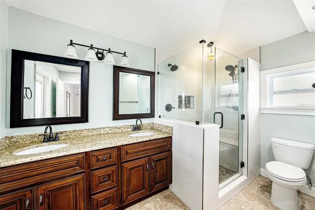 a bathroom with a granite countertop sink toilet and shower