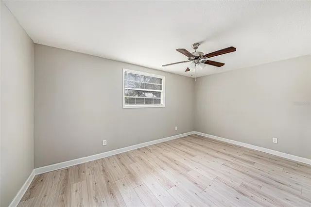 a view of a room with wooden floor and a ceiling fan