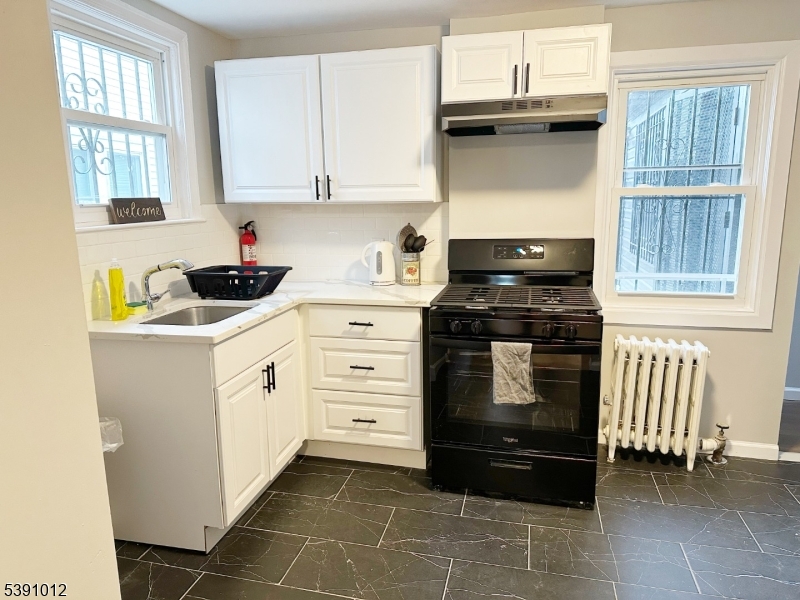 26 Duryea Street Newark, NJ 07103 - Photo 4 of 15 a kitchen with white cabinets and appliances