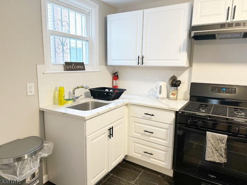 26 Duryea Street Newark, NJ 07103 - Photo 5 of 15 a kitchen with white cabinets and appliances