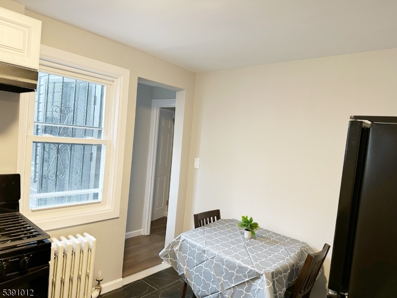26 Duryea Street Newark, NJ 07103 - Photo 7 of 15 a view of a kitchen area with furniture and wooden floor