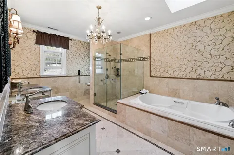 a bathroom with a granite countertop sink a mirror and shower