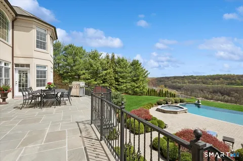 a view of a patio with table and chairs and potted plants with wooden floor and fence