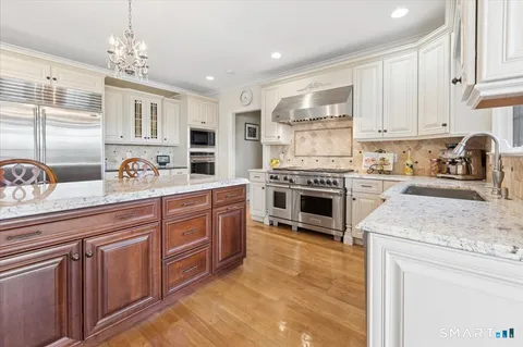 a kitchen with stainless steel appliances granite countertop a stove sink and cabinets