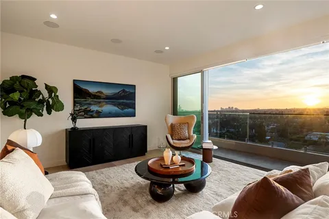 a living room with furniture a rug and a floor to ceiling window