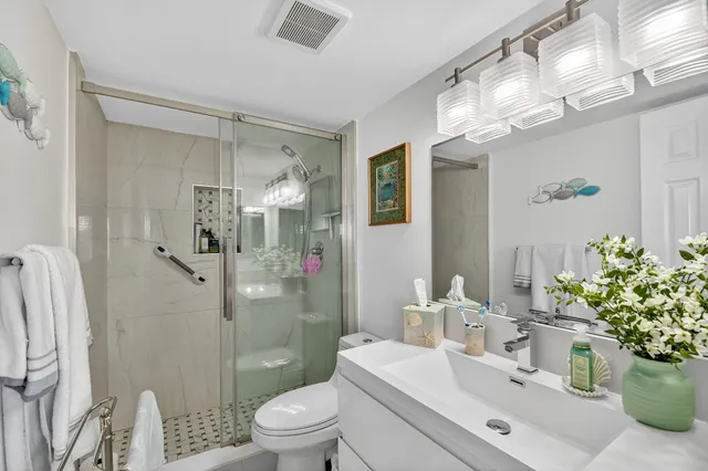 a bathroom with a sink a mirror a toilet and a mirror